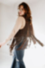 Emaline Audra studio portrait action shot wearing a beaded vintage 70's vest and twirling