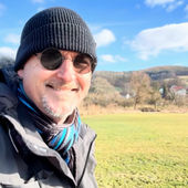 Jan Luley mit Winterjacke und Mütze in der Natur mit Hüglen im Hintergrund