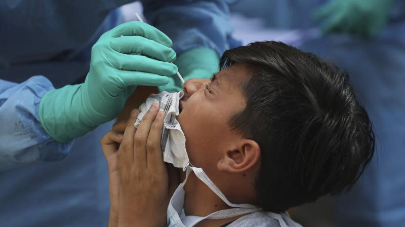 Associated Press photo of a boy in India undergoing a swab test. Source: Asian Age