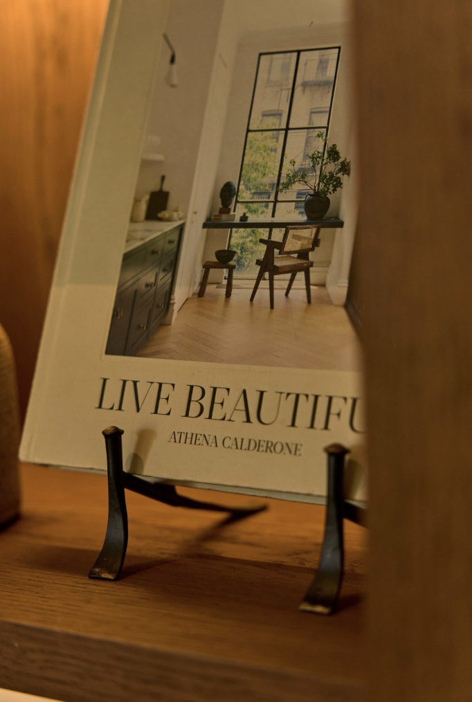 Book cover, Live Beautiful by Athena Calderone, on a stand in a room.