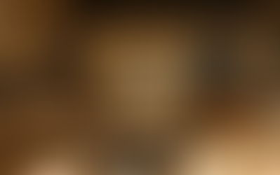 Restaurant interior with wooden tables and chairs, decorative wall, and ambient lighting.