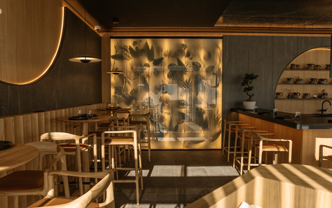Restaurant interior with wooden tables and chairs, decorative wall, and ambient lighting.