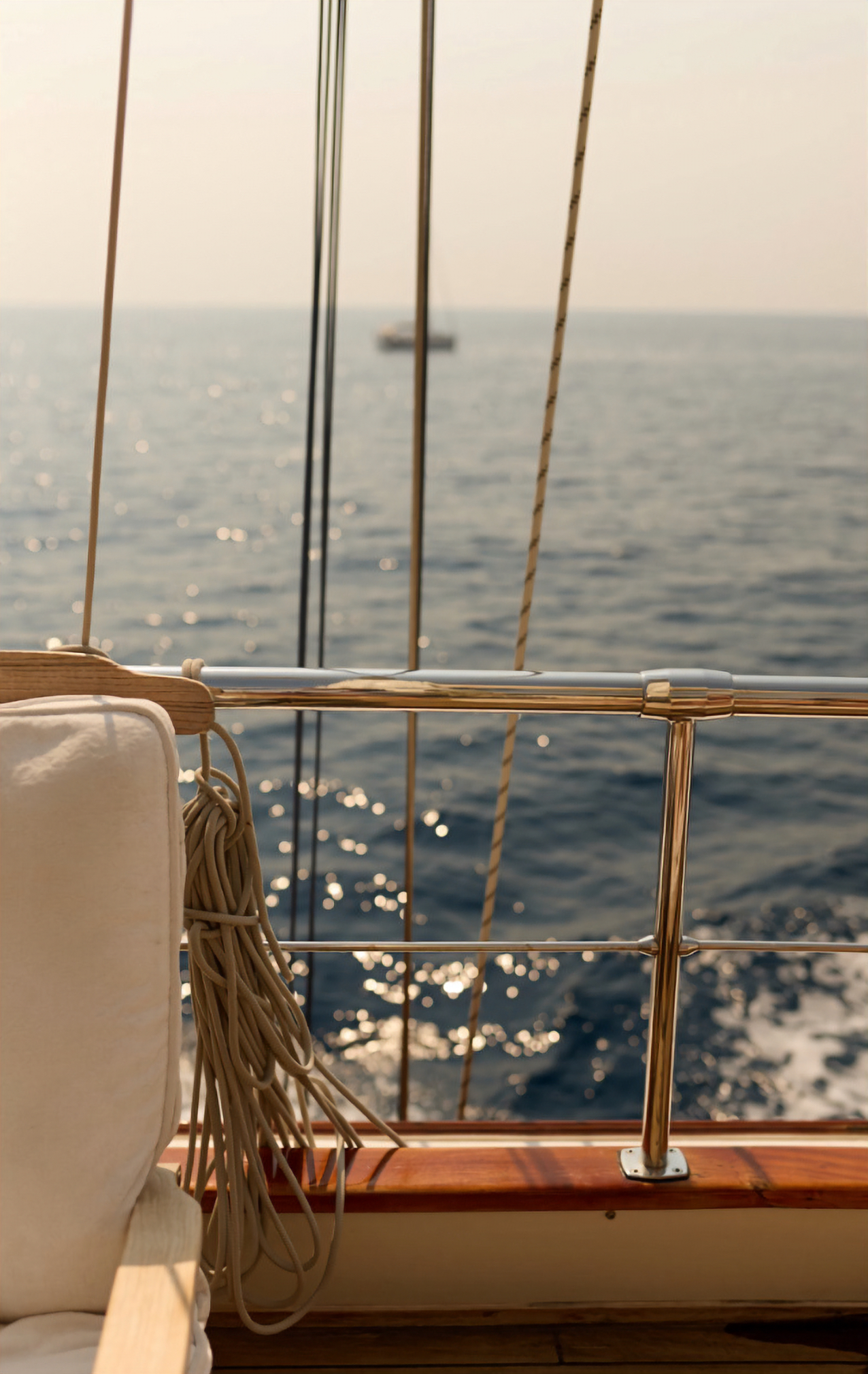 Wooden yacht on water with rope and railing, peaceful sea view