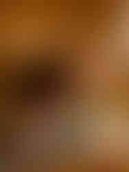 Hand placing sushi with wasabi and ginger on a black plate, indoor shot