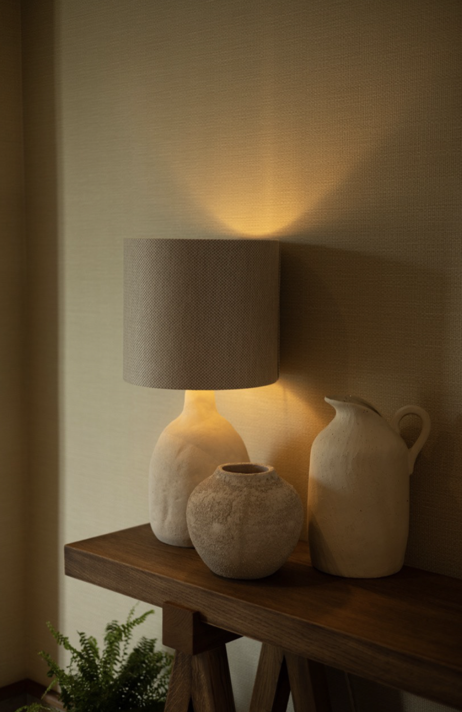 Table lamp with vases illuminated on a wooden table, warm light.