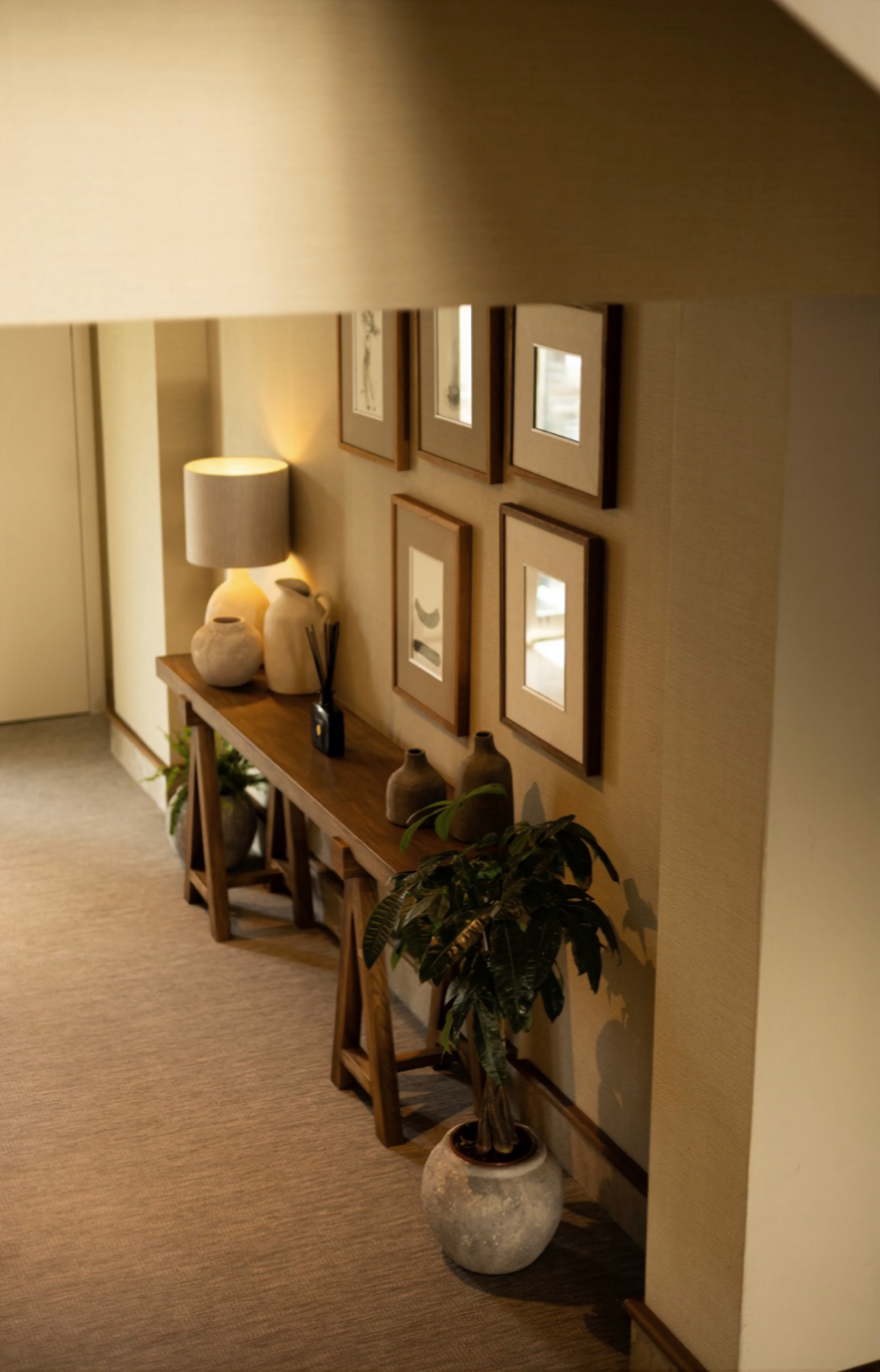 Wooden console table with framed art and decor in a hallway setting