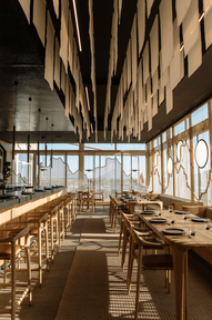 Elegant restaurant interior with wooden furniture and decorative paper hanging from ceiling.