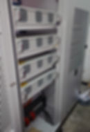 Industrial electrical rack with stacked server modules.
