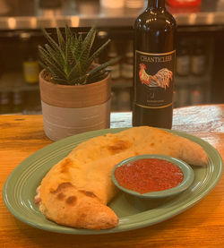 Golden-brown calzone filled with mozzarella cheese, Italian meats, and savory toppings