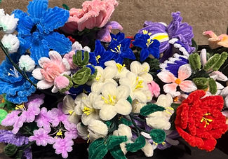 an assortment of handmade pipe cleaner flowers