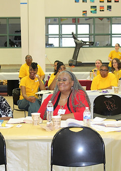 people are pictured sitting around tables at a conference