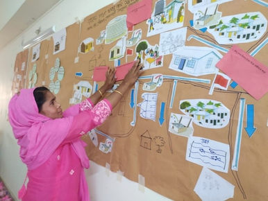 Participant in the first IMT-SWSS workshop in Godagari placing input on integrity red flags on the community water system map