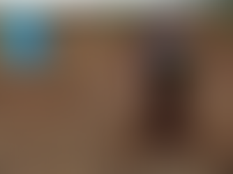 woman in a field in India refilling a DIY plastic bottle drip irrigation system from a metal jug