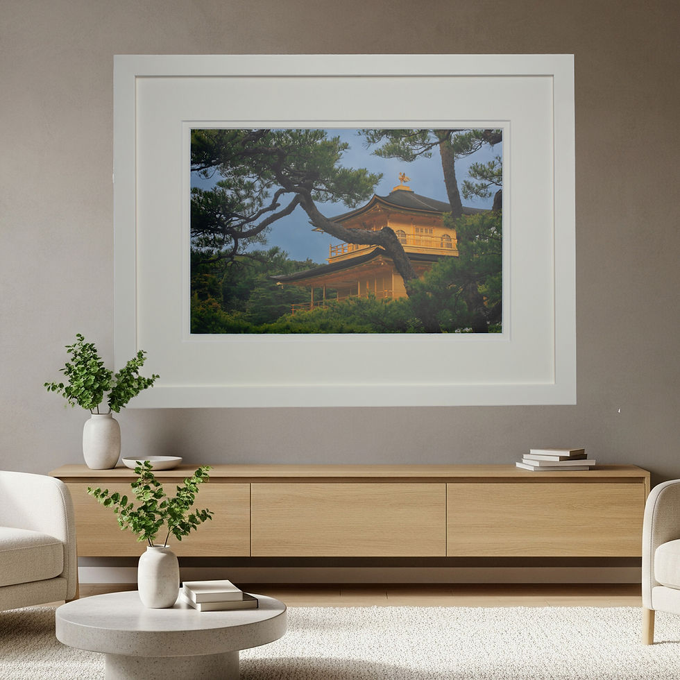A artistically photograph wall art print of the Golden Pavilion seen through the trees in a white frame displayed in a room