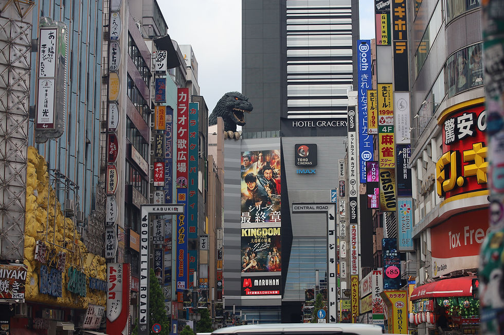 An image of Toyko streets with Godzilla above the buildings