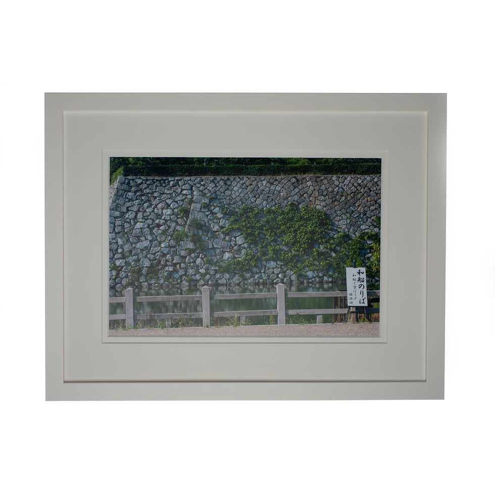 An artistic print of a wall with a Japanese sign next to it in a white frame