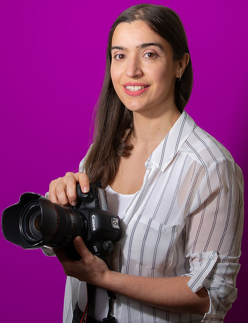Belinda Vecchio holding her camera on a pink background
