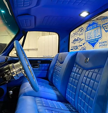 View of blue leather upholstery on the seats and steering wheel of a car