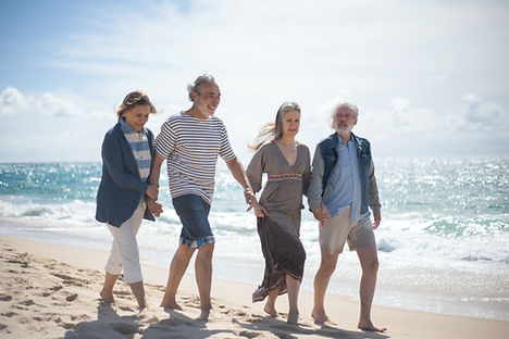 group of elderly people walking on the beach side