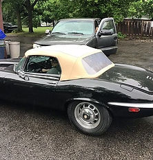 Side view of a black convertible vintage car with upholstered roof