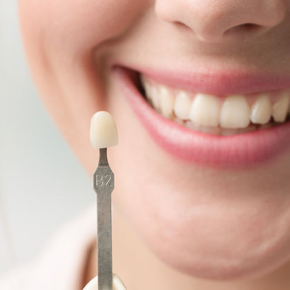 A picture of a woman holding a tooth.