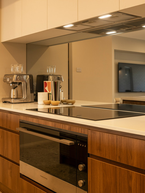 Mid-Century Modern kitchen with wooden cabinets, stone floor, and mirrored splashback.