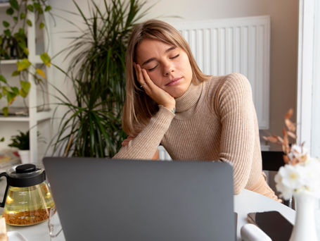 An exhausted woman in front of the computer.