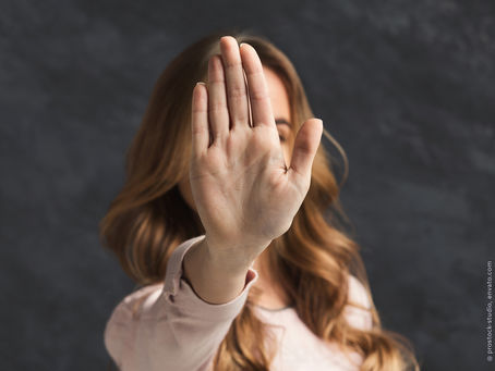 Eine Frau, die eine Hand vor ihren Kopf nach oben hält und damit ausdrückt: Stopp, keinen Schritt weiter