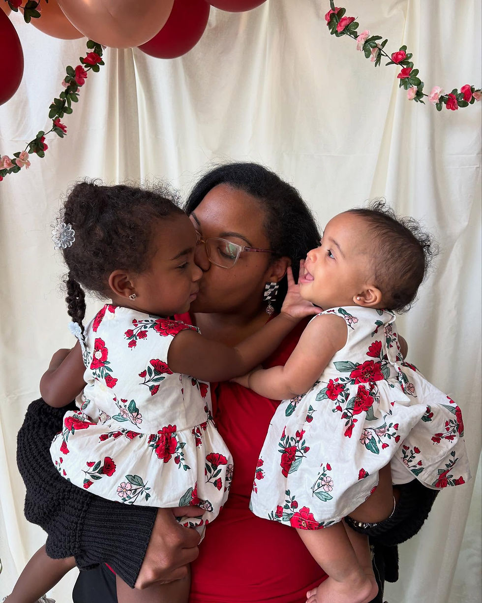 Mom holding two daughters and kissing one