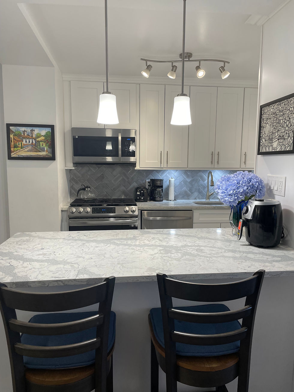 Small kitchen with mixed light sources: under cabinet, overhead, and pendant lighting