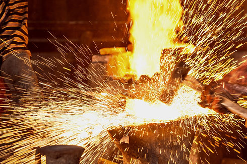 Blacksmith forging the molten metal with