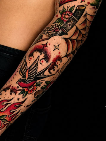 รอยสักแขนสไตล์ Old School รูปนกนางแอ่น กุหลาบ และไฟ โดย LotusbiteTattoo