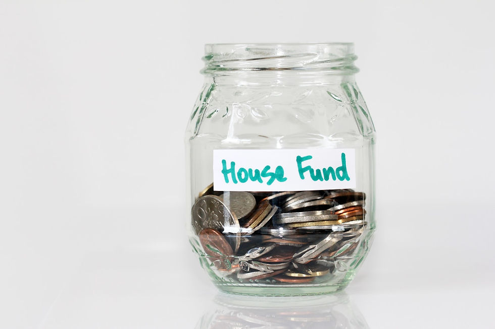 A clear jar with change and a piece of tape marked "House Fund"
