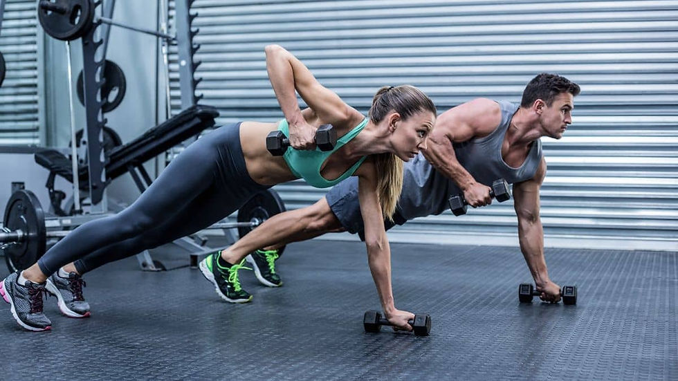 caucasian couple at the gym lifting dumbells trying to find how can you build muscle in calorie deficit