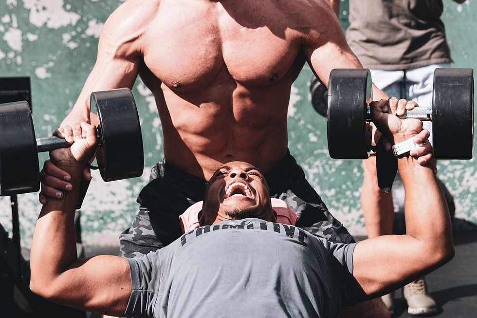 a man perform dummble chest press on bench with he's partner helping hem to lift more for how fast he can build muscle
