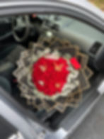 Red roses with butterflies and a crown in a black wrapping paper bouquet 