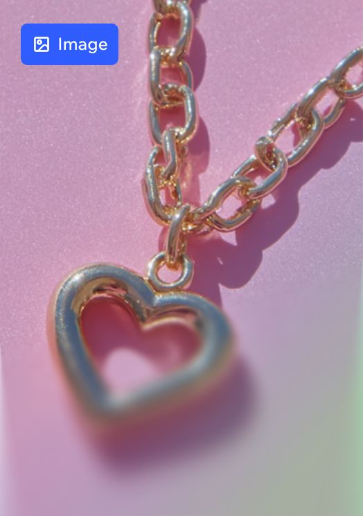 A gold, chain-link necklace with a heart-shaped pendant against a textured pink background.