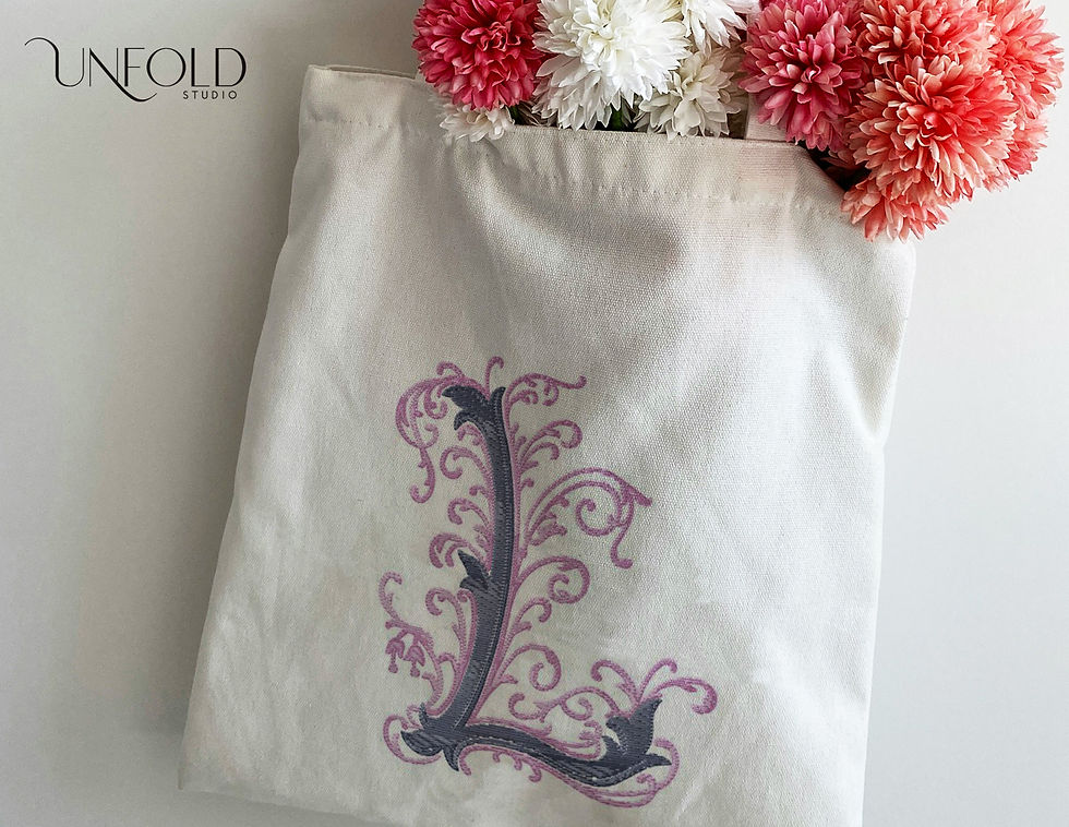 Thumbnail: Embroidered-style decorative letter L with elaborate swirls and scrolls, featuring intricate, flowing designs.