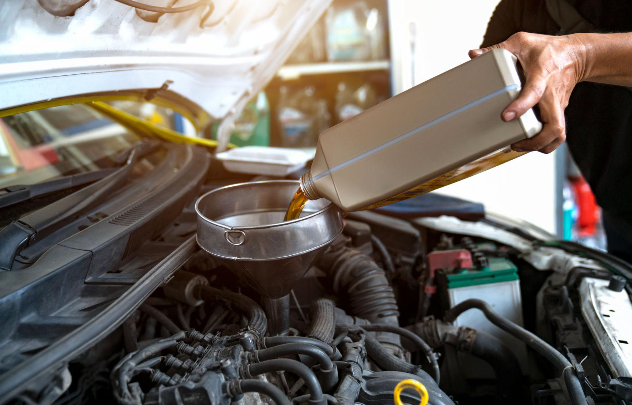 Adding oil to a car engine during an oil change.