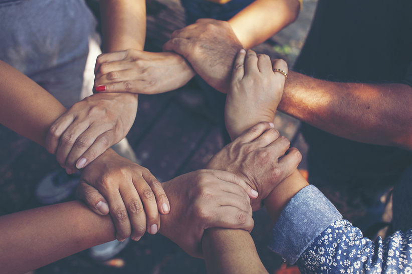 multiple hands grasping each other