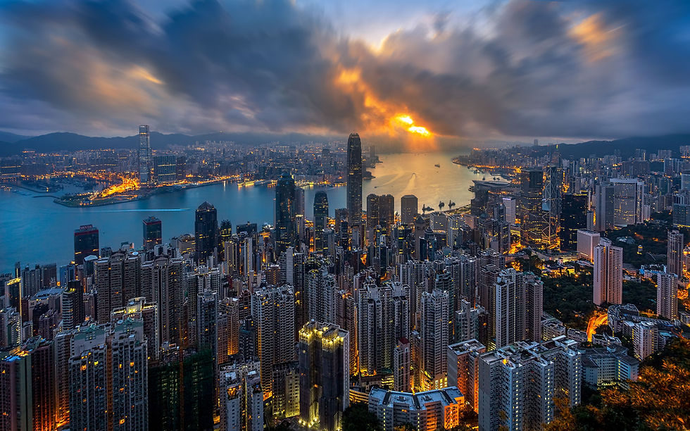 Wide landscape city skyline at sunset with dramatic clouds and lights, strong blue and orange contrast