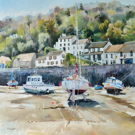Tides out in a walled harbour, anchored yachts and fishing boats
