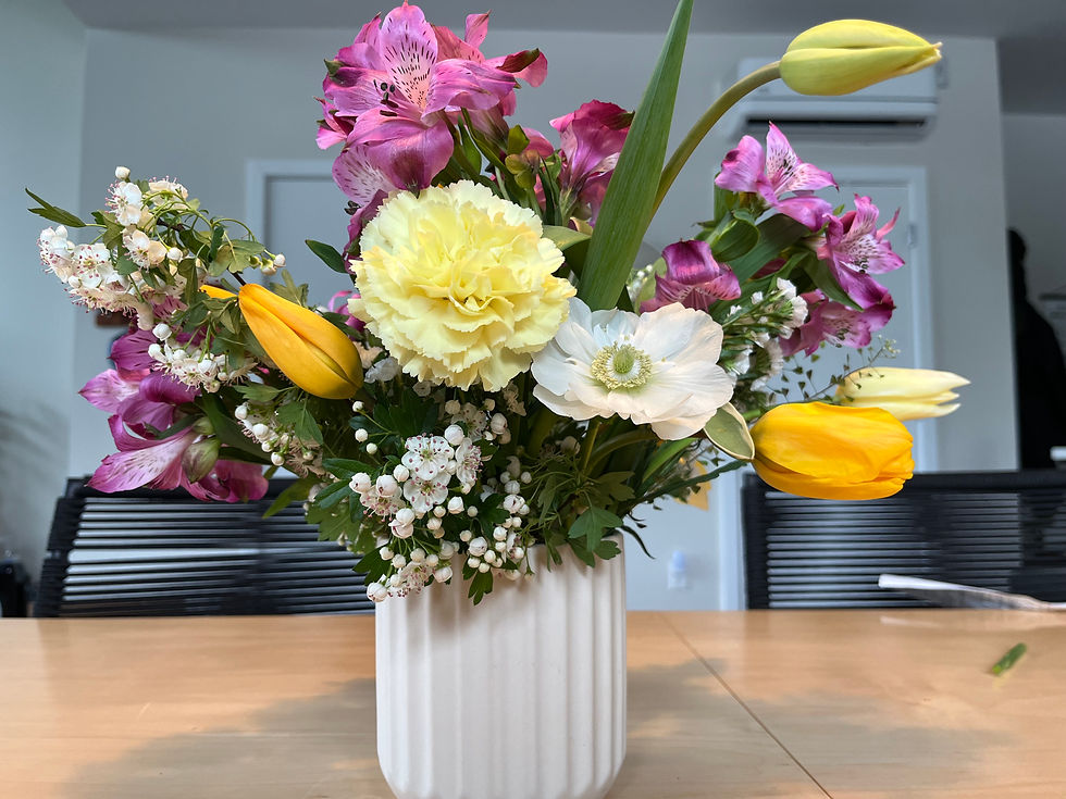 Thumbnail: A bouquet with yellow and purple flowers in a while vase.