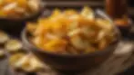 Close-up view of golden-brown potato chips cooked in beef tallow in a rustic bowl