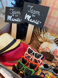 Lot d'accessoires tels que des chapeaux, des lunettes, des pancartes dans une valise vintage