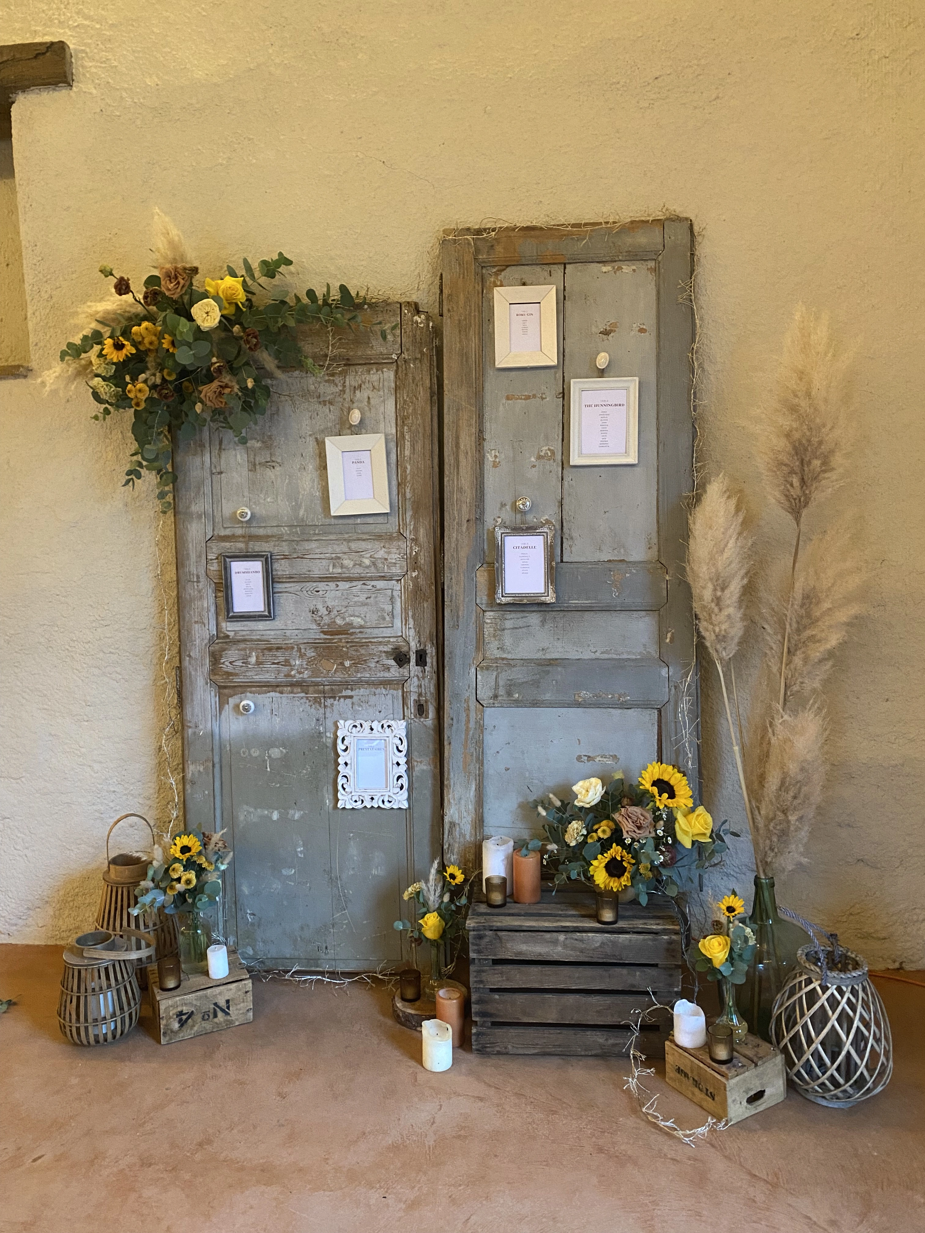 plan de table avec récup de vieille porte en bois et compositions florales tournesol pour un mariage