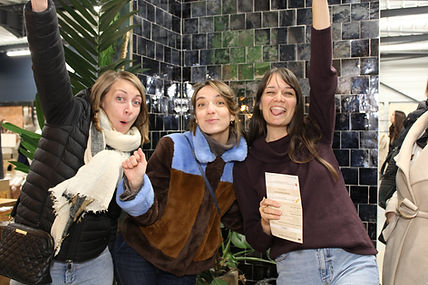 Un groupe de trois filles faisant une pose marrante devant un photobooth lors d'une soirée girl power