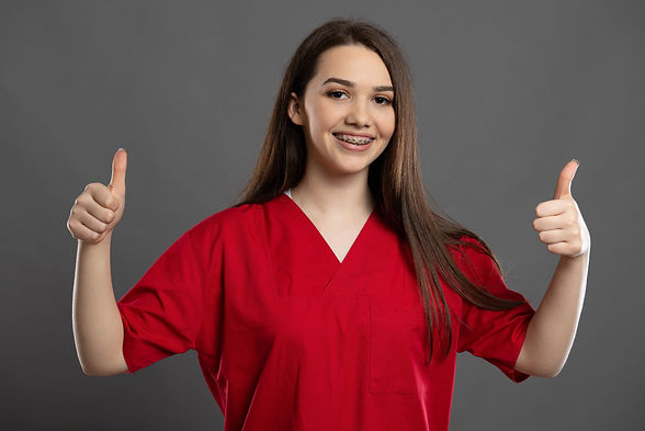 Cheeky young nurse smiling and giving tw