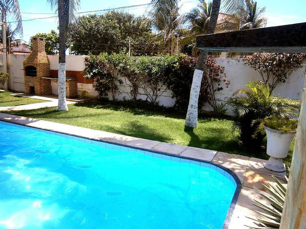 Piscina residencial con sistema de calefacción solar instalado en el techo, compuesto por paneles térmicos negros conectados a la bomba de la piscina.