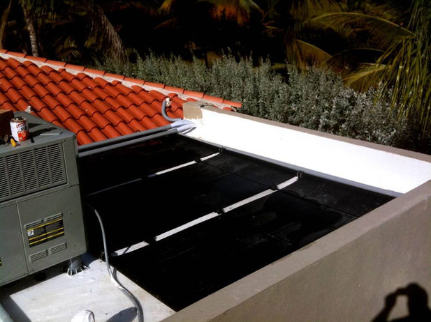 Paneles solares y sistema de control automatizado para calefacción de piscina residencial instalados en techo y pared exterior.